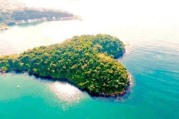 Vista aérea da Praia do Sossego em Niterói, com vegetação exuberante e águas cristalinas.