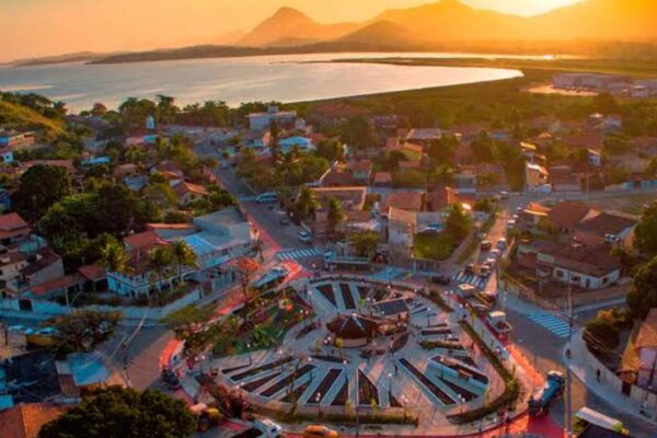 Vista aérea de Maricá, Costa do Sol, com lago e cidade ao pôr do sol.
