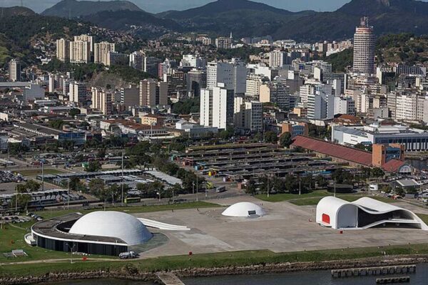 Vista aérea de Niterói, cidade de alto padrão no Rio de Janeiro, com edifícios modernos e paisagens exuberantes.