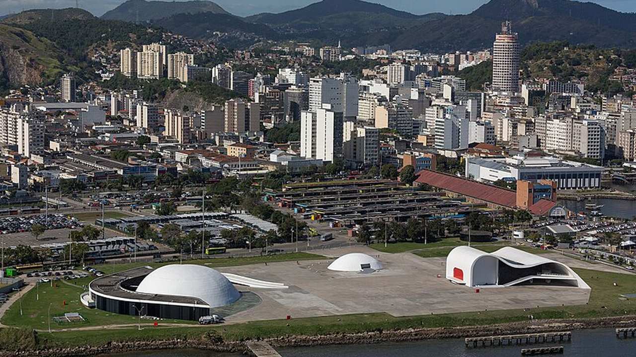 Vista aérea de Niterói, cidade de alto padrão no Rio de Janeiro, com edifícios modernos e paisagens exuberantes.
