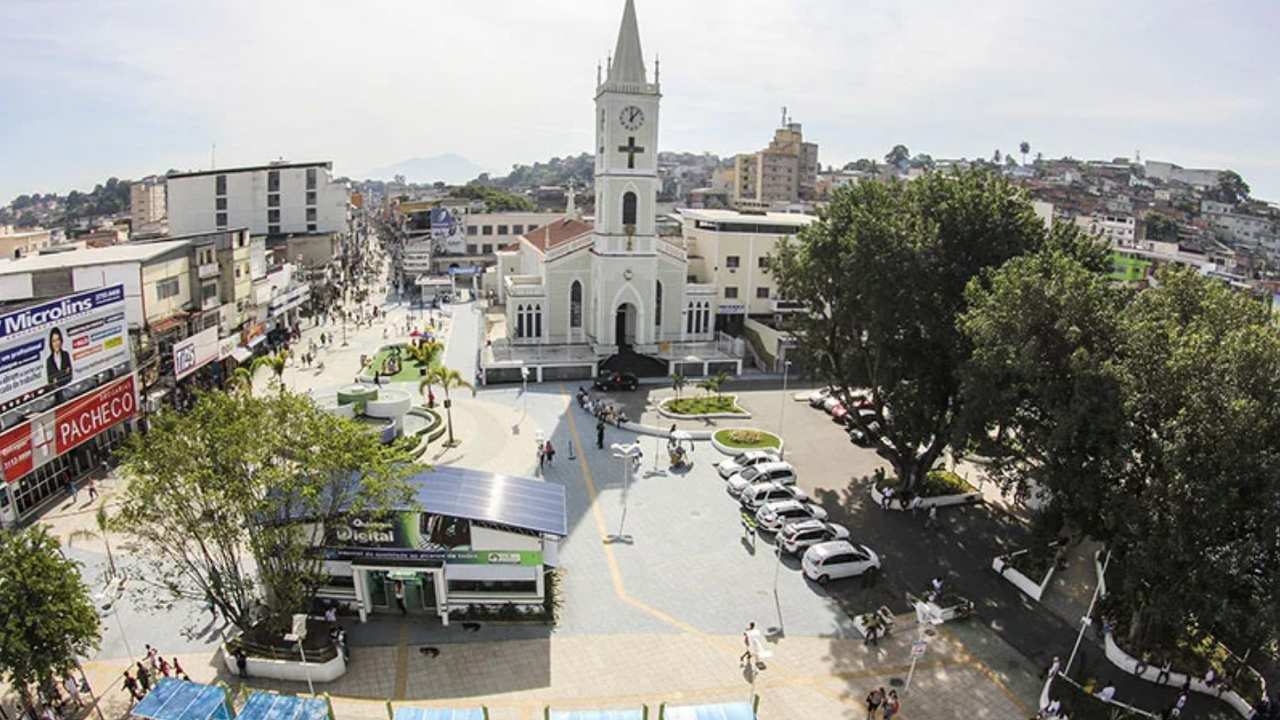 Vista aérea de São João de Meriti, com igreja, edifícios e praça.