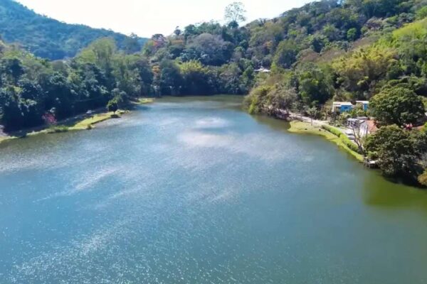 Vista aérea do Lago do Caiçara, em Barra do Piraí, com vegetação exuberante e construções.