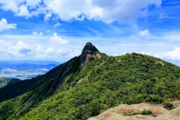 Vista deslumbrante da Pedra das Flores em São José do Vale do Rio Preto, com céu azul e vegetação exuberante.
