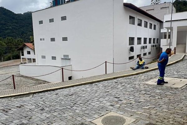 Vista externa do Hospital do Câncer de Nova Friburgo em construção, mostrando um pátio com piso de paralelepípedos.