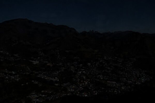 Vista noturna de Nova Friburgo com bairros escuros devido à falta de energia.