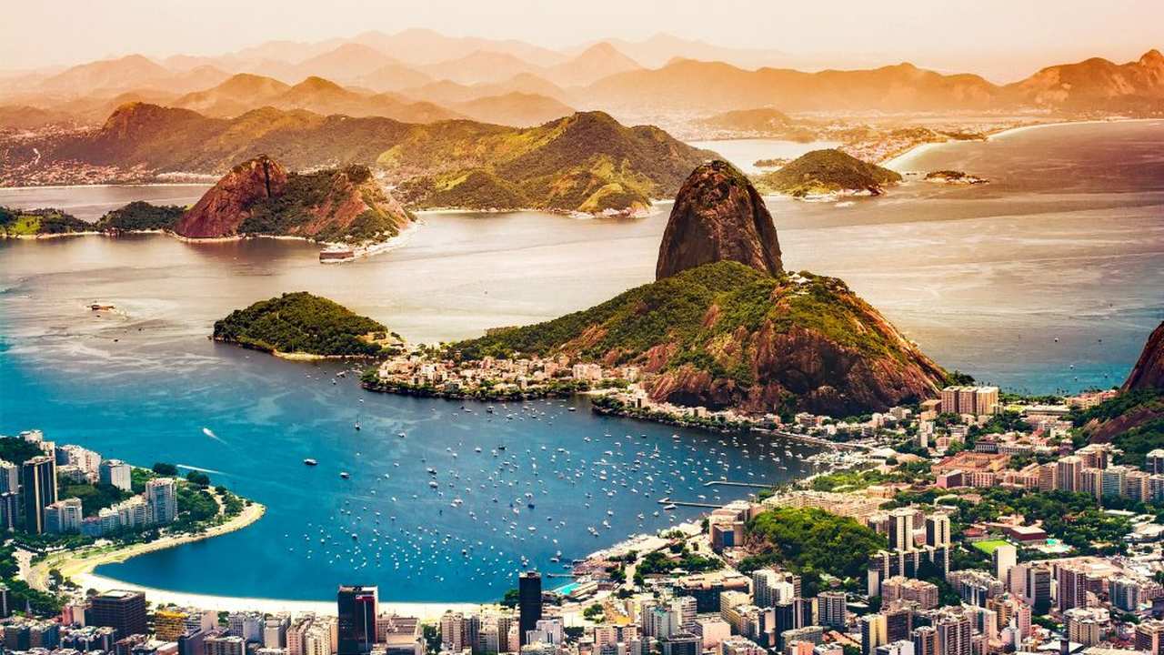 Vista panorâmica da Baía de Guanabara, Rio de Janeiro, com Pão de Açúcar e cidade ao fundo.