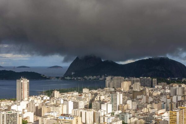 Vista panorâmica da cidade do Rio de Janeiro com céu nublado, indicando instabilidade climática.
