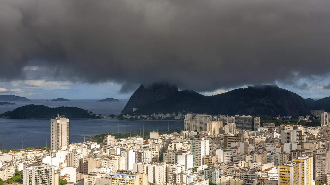 Vista panorâmica da cidade do Rio de Janeiro com céu nublado, indicando instabilidade climática.