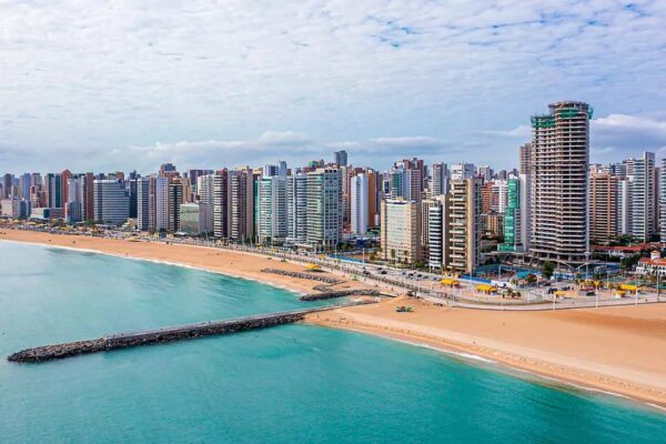 Vista panorâmica da orla de Fortaleza, com edifícios modernos e praia.