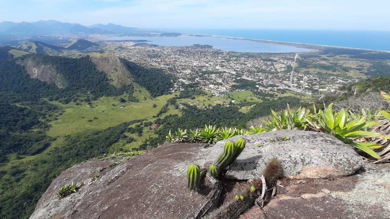 Vista panorâmica da Pedra de Inoã, em Maricá, com cidade, lagoa e mar ao fundo.