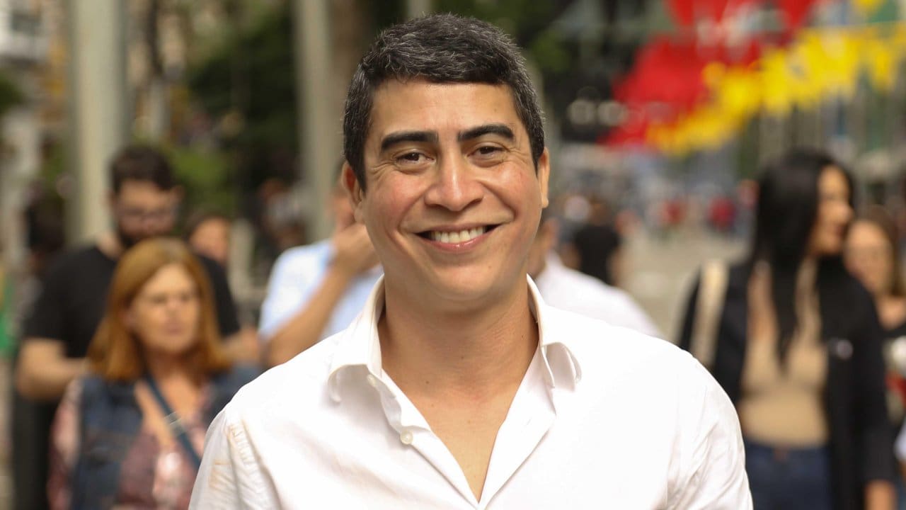 Wanderson Nogueira sorrindo em meio a pessoas, em um evento ao ar livre.