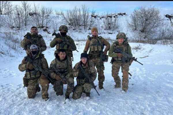 Yasmin Carpi e outros combatentes na Ucrânia, em meio à neve, segurando armas.