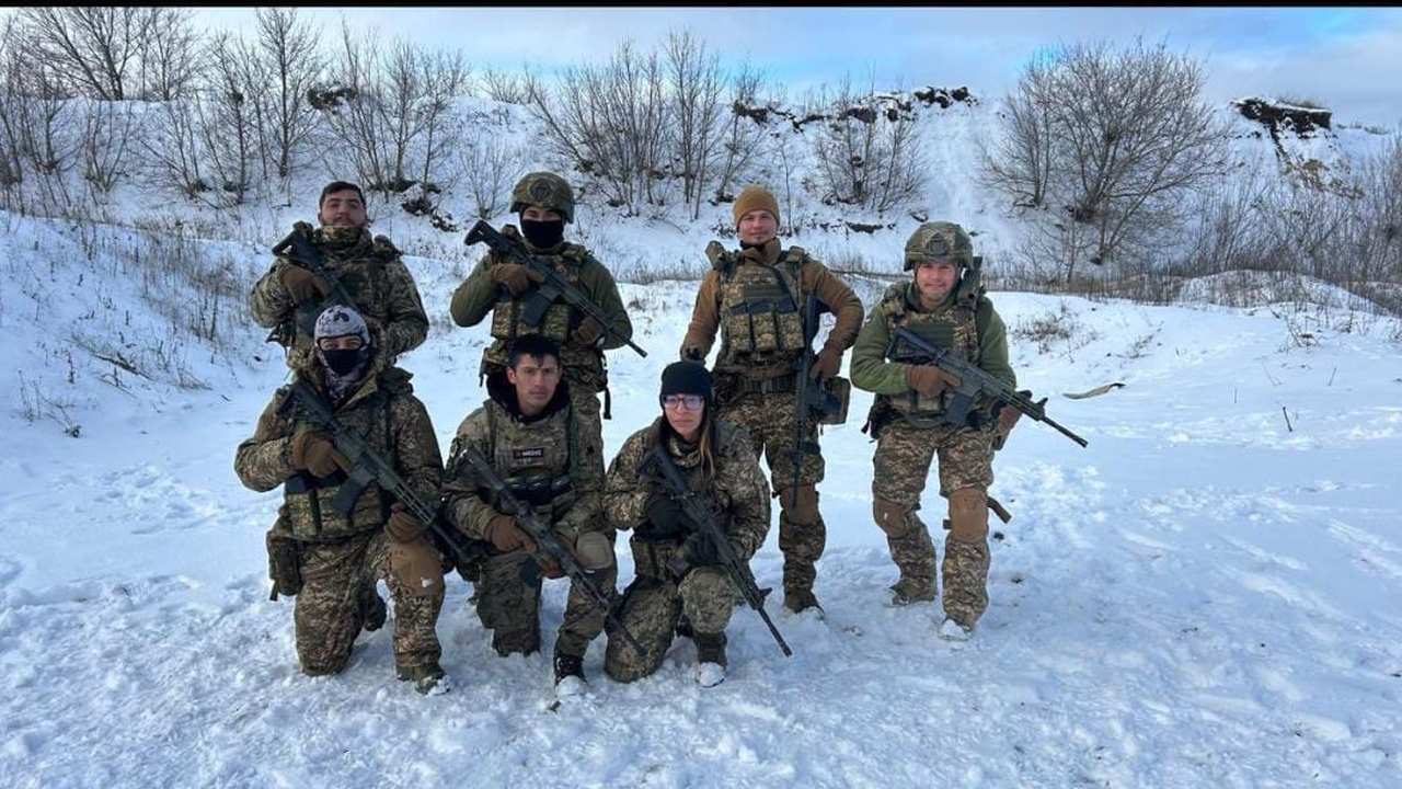 Yasmin Carpi e outros combatentes na Ucrânia, em meio à neve, segurando armas.