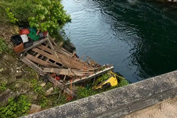 Caminhão destruído às margens do rio após sair da pista na RJ-142, próximo à Ponte de Santa Luzia.
