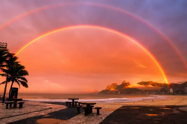 Arco-íris duplo aparece sobre o céu da Zona Sul do Rio de Janeiro durante o amanhecer.