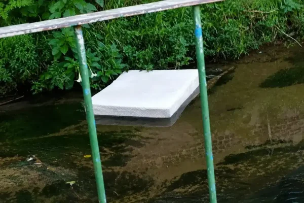 Colchão de casal boia dentro do córrego que corta a Avenida Campesina Friburguense, em Nova Friburgo.