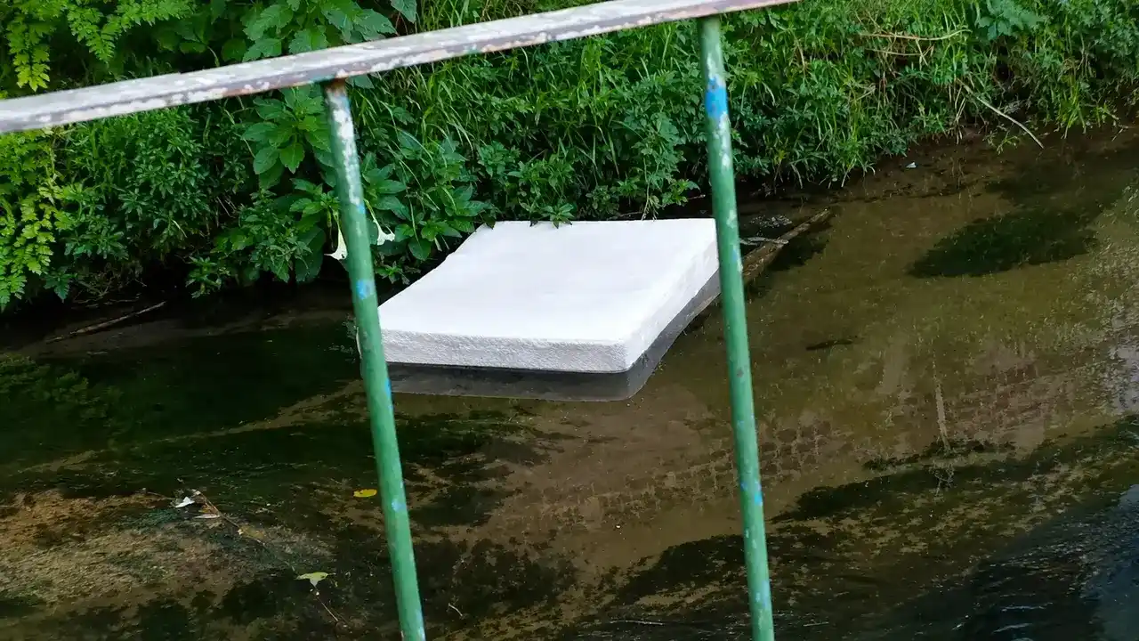 Colchão de casal boia dentro do córrego que corta a Avenida Campesina Friburguense, em Nova Friburgo.