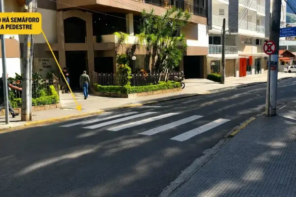 Pessoas prestam socorro a uma mulher caída na pista após atropelamento em cruzamento no Centro de Nova Friburgo.