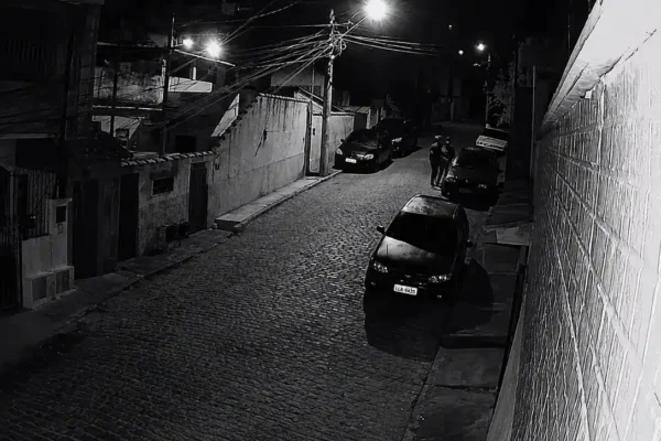 Dois homens usando capacetes aparecem durante a madrugada próximos a um veículo estacionado na Rua Humaitá, no bairro Perissê.