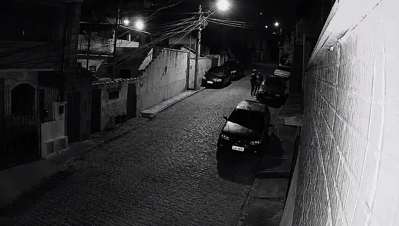 Dois homens usando capacetes aparecem durante a madrugada próximos a um veículo estacionado na Rua Humaitá, no bairro Perissê.