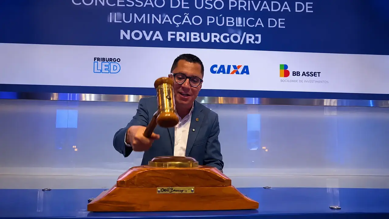 Prefeito Johnny Maycon durante anúncio da PPP de iluminação pública de Nova Friburgo, ao lado de imagem do recurso administrativo obtido pelo EcoSerrano.