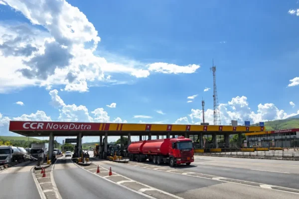 Praça de pedágio da Rodovia Presidente Dutra com caminhões e automóveis nas pistas