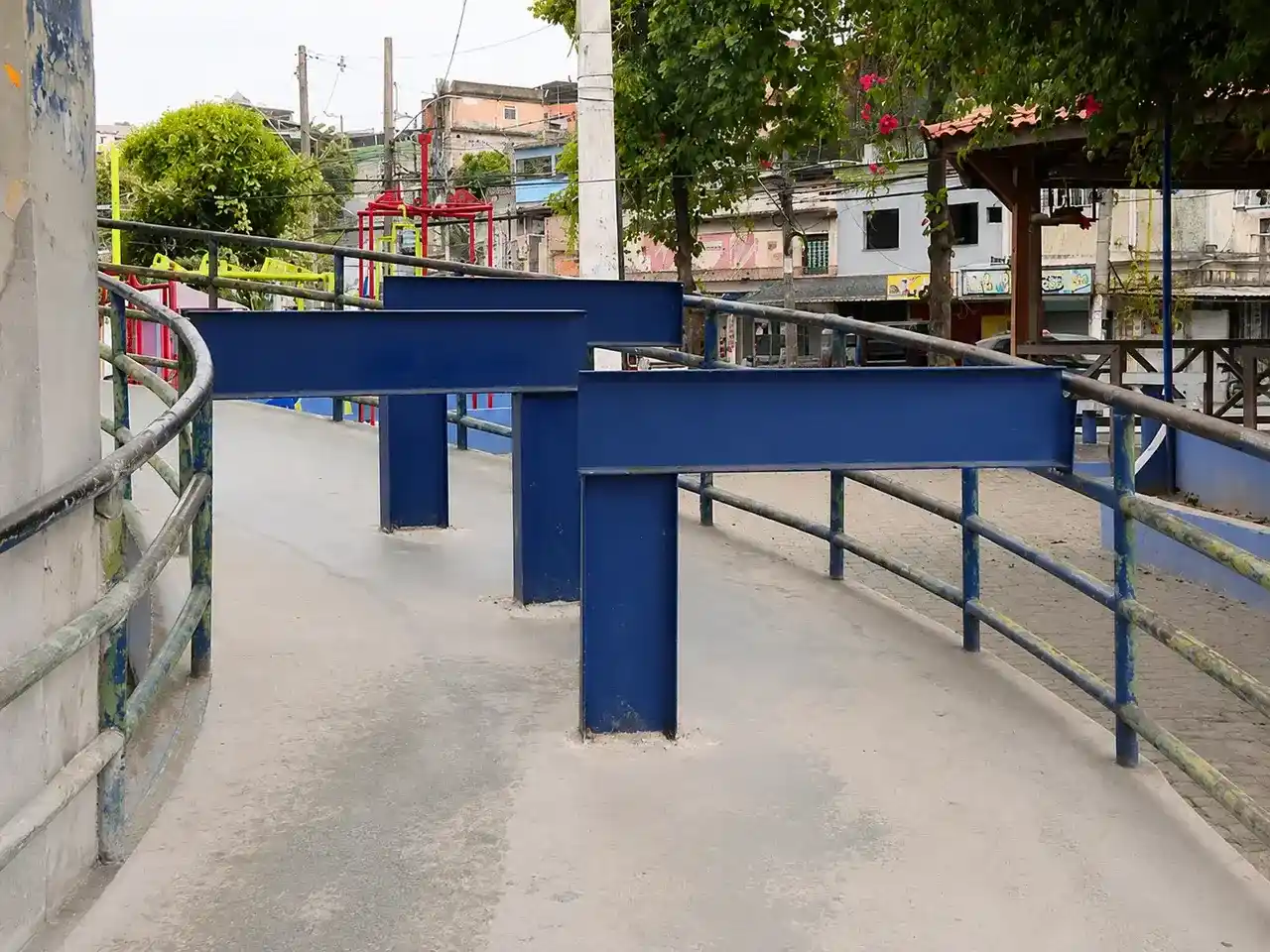 Passarela de Gramacho com grandes barreiras azuis instaladas no caminho para impedir a circulação de motos.