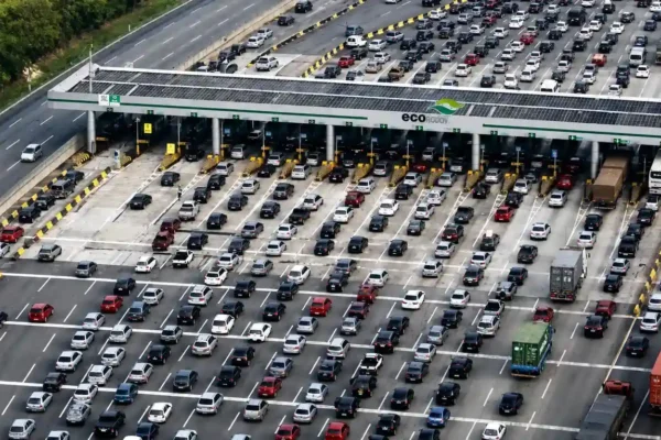 A imagem mostra uma praça de pedágio em uma rodovia paulista, com várias cabines de cobrança e veículos passando pelas pistas.