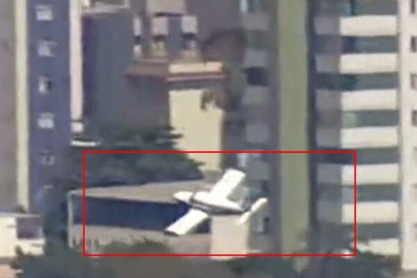 Acidente aéreo em área residencial: aeronave caída em meio a prédios.