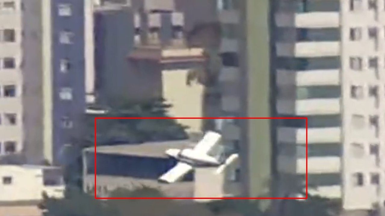 Acidente aéreo em área residencial: aeronave caída em meio a prédios.