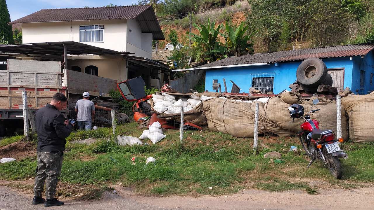 Acidente de caminhão em Amparo, Nova Friburgo, com veículos danificados e destruição.
