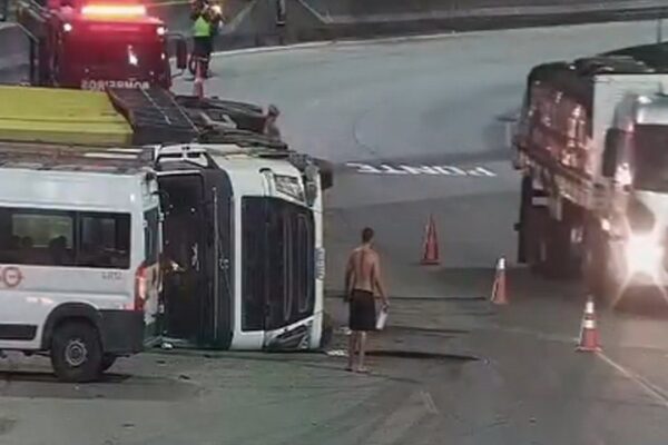 Acidente na Avenida Brasil: Ônibus tombado e veículos de emergência no local.