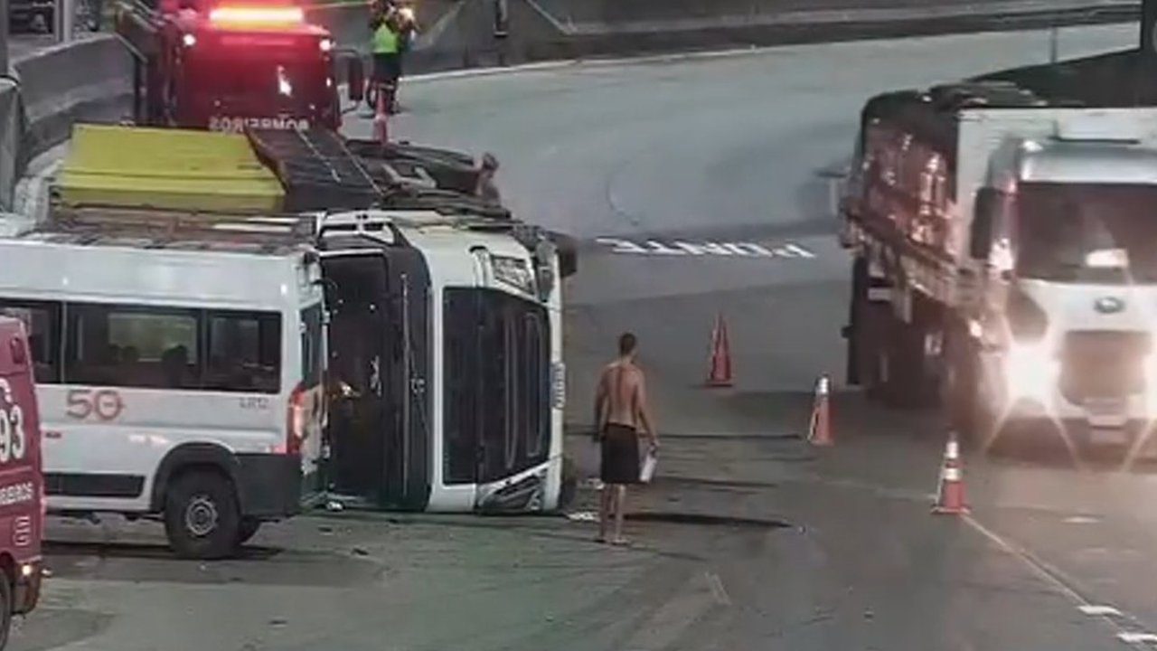 Acidente na Avenida Brasil: Ônibus tombado e veículos de emergência no local.