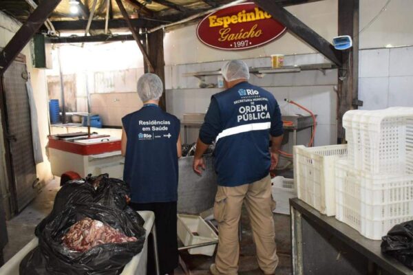 Agentes da prefeitura inspecionam local com alimentos apreendidos.