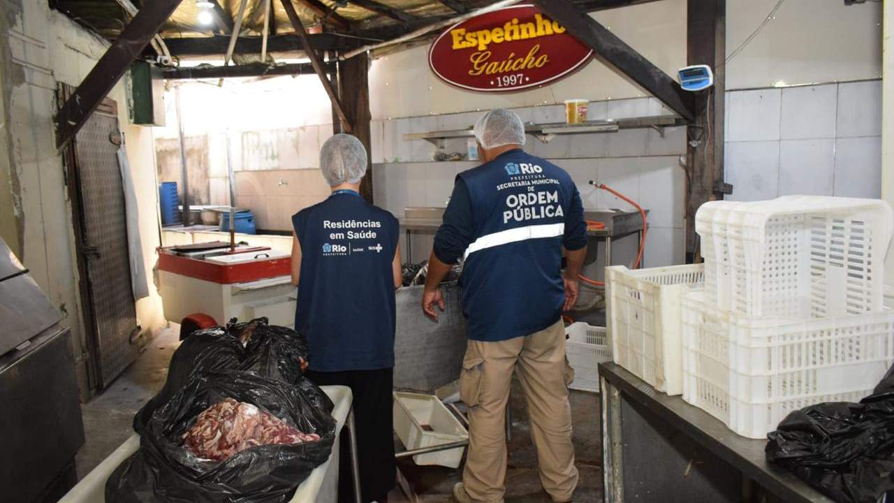 Agentes da prefeitura inspecionam local com alimentos apreendidos.