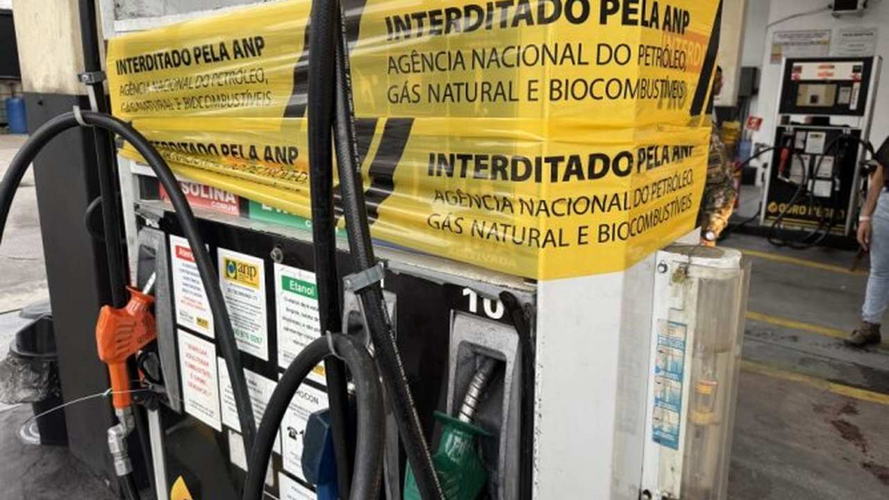 Bomba de gasolina interditada pela ANP em posto de combustível no Rio de Janeiro, com fita de interdição e texto em português.