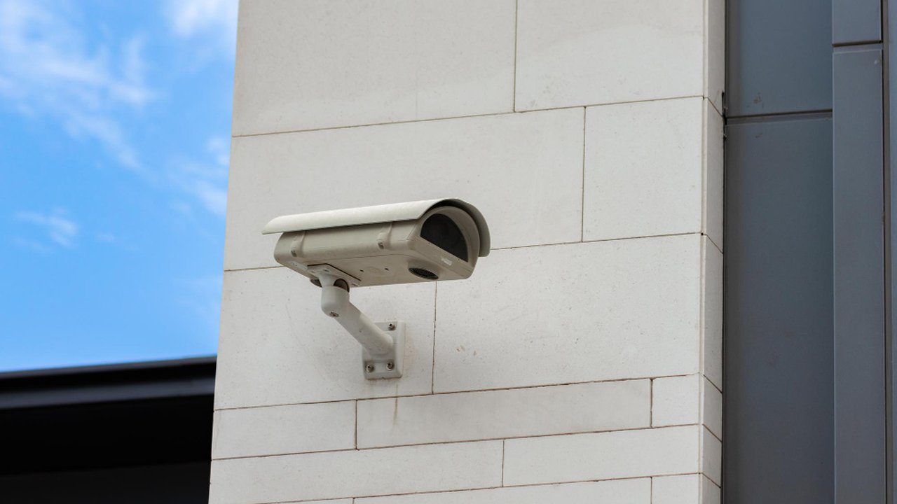 Câmera de segurança instalada em parede branca