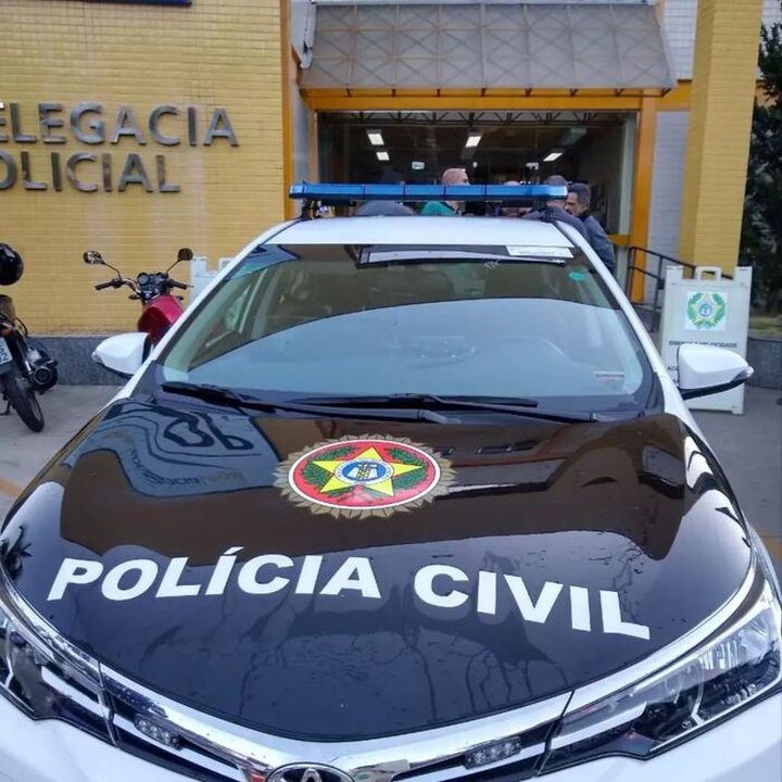 Carro da Polícia Civil estacionado em frente à delegacia.