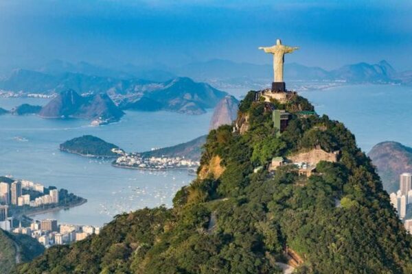 Cristo Redentor no topo do Corcovado, Rio de Janeiro, com vista para a cidade e o oceano.