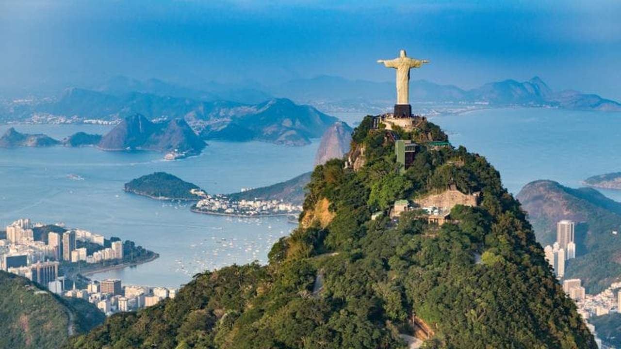 Cristo Redentor no topo do Corcovado, Rio de Janeiro, com vista para a cidade e o oceano.