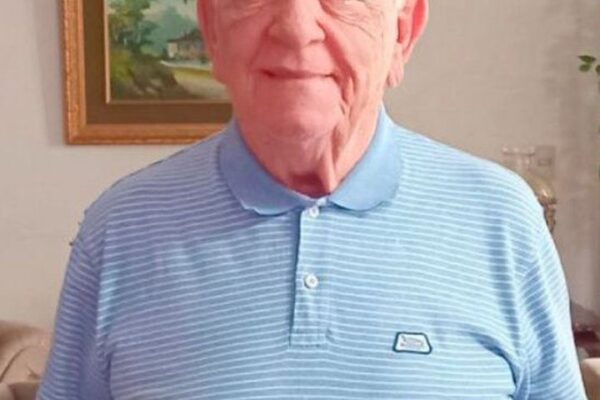 Dr. Carlos Pecci em retrato sorrindo, usando camisa polo azul clara
