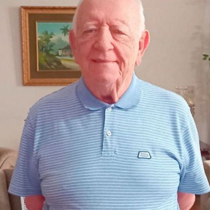 Dr. Carlos Pecci em retrato sorrindo, usando camisa polo azul clara