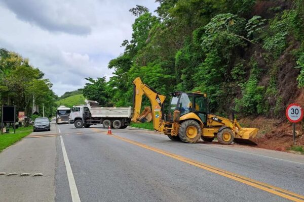 Equipamentos de obras na rodovia, com tráfego limitado e sinalização.