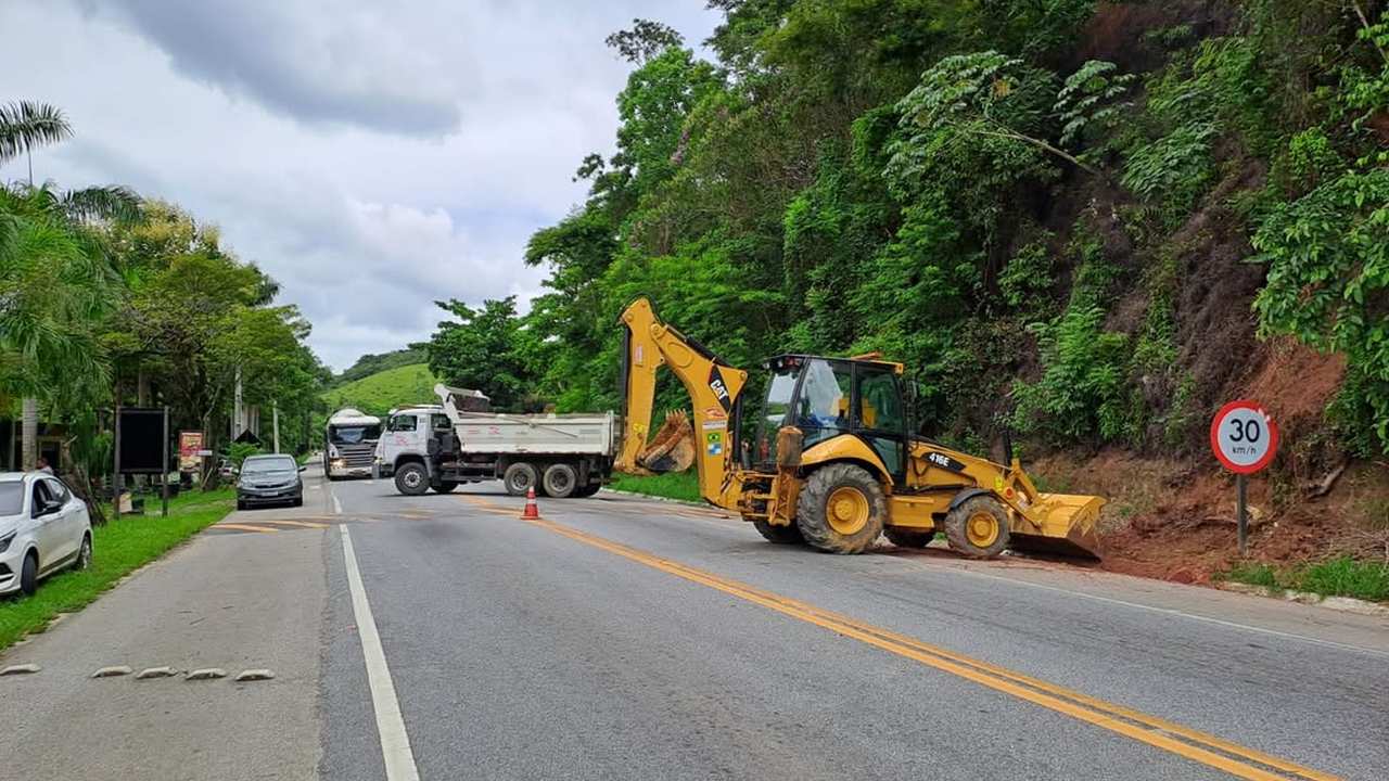 Equipamentos de obras na rodovia, com tráfego limitado e sinalização.