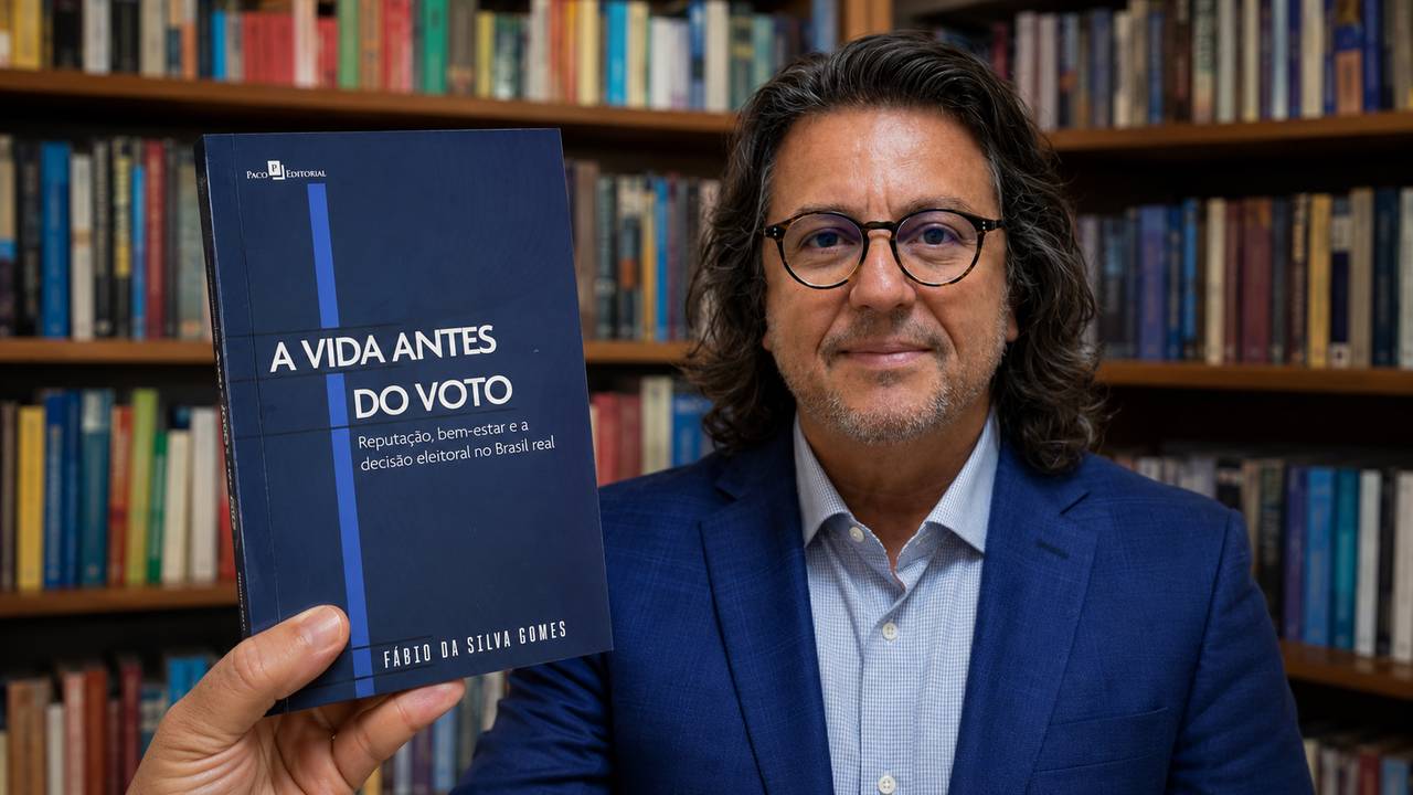 Sociólogo Fábio Gomes apresenta o livro “A Vida Antes do Voto” diante de uma estante de livros.