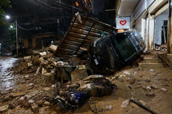 Via interditada após chuva e equipes trabalhando na retirada de terra e no reparo de uma rede no Rio de Janeiro.