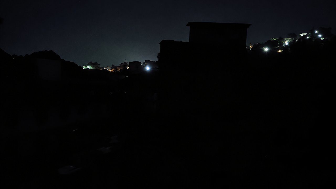 Rua do bairro Cordoeira durante a noite, com imóveis sem iluminação após interrupção no fornecimento de energia.