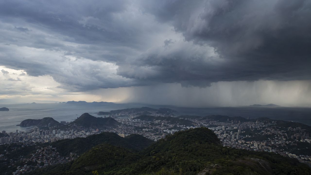 Nuvens carregadas avançam sobre montanhas e cidades do Estado do Rio antes da chegada de uma frente fria.
