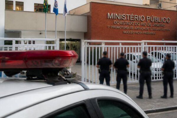 Fachada do Ministério Público no Rio de Janeiro com viatura policial.