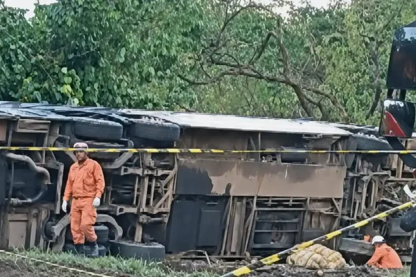 Ônibus tombado às margens da BR-040, em Petrópolis, com bombeiros trabalhando na área isolada.